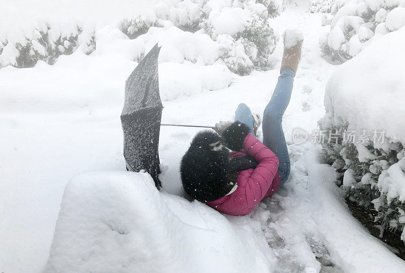 女人倒在地上，在新雪/冰上滑倒